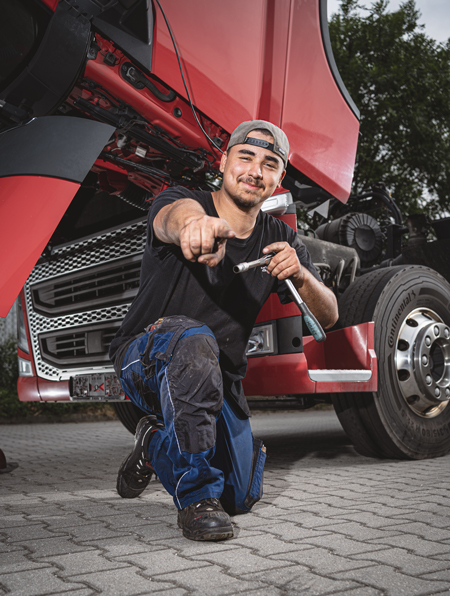 benefits angerer Mitarbeiter kniet vor LKW